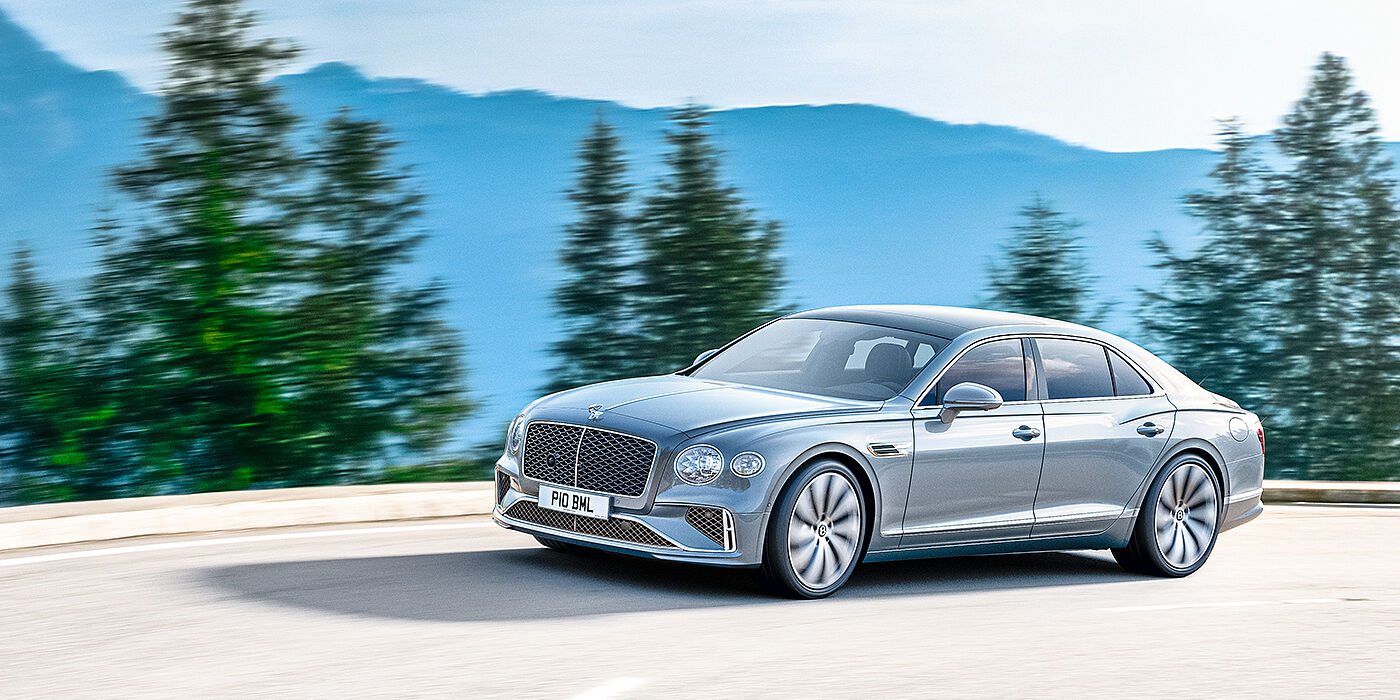 Jack Barclay New Bentley Flying Spur sedan side view in Silverlake paint with ten spoke wheels and chrome matrix grille driving dynamically on a mountain road