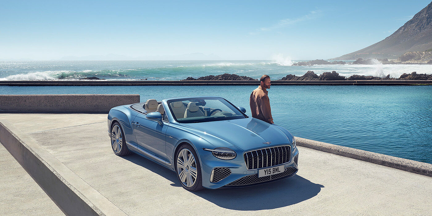 Jack Barclay New Bentley Continental GTC Azure convertible front view in Light Windsor blue paint with 22 inch ten spoke wheels parked by the sea in the sunshine