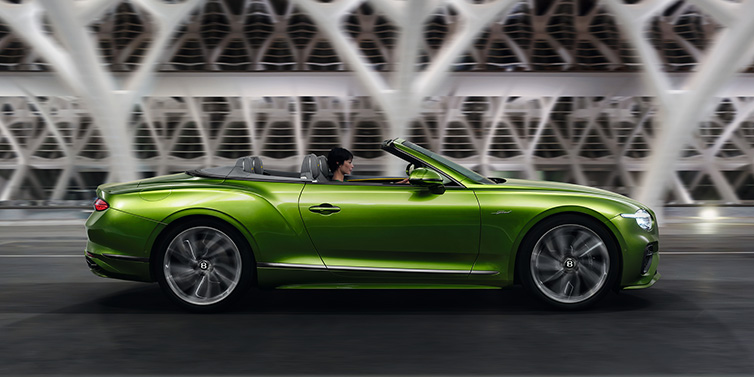 Jack Barclay Bentley Continental GTC Speed convertible side profile in Tourmaline Green paint driving dynamically on a bridge at night